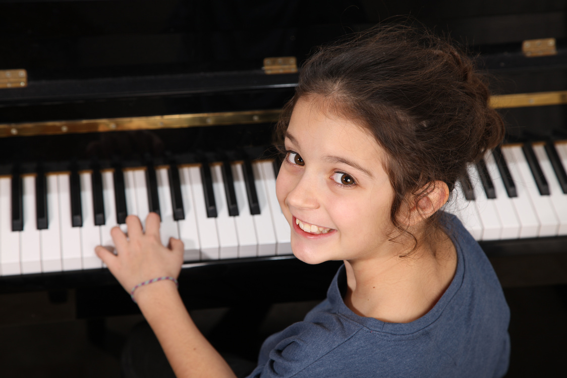 Young girl smiling during a piano lesson